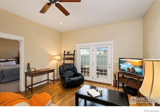 living area with ceiling fan, baseboards, and wood finished floors