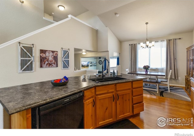 kitchen featuring dark countertops, an inviting chandelier, a sink, wood finished floors, and dishwasher