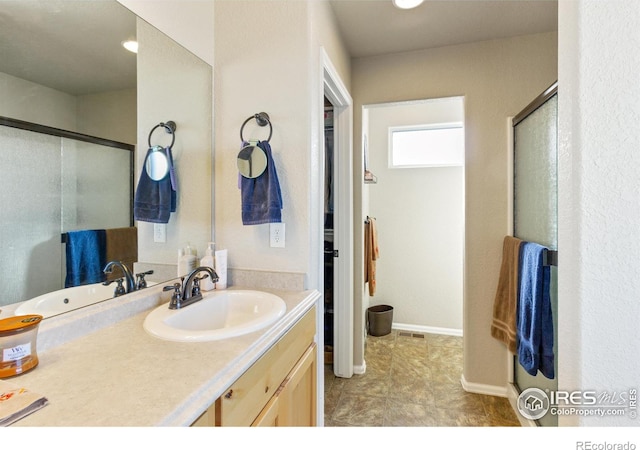 full bathroom featuring vanity, a shower stall, visible vents, and baseboards