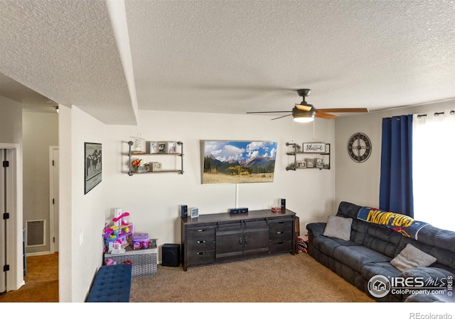 carpeted living room featuring a textured ceiling and ceiling fan