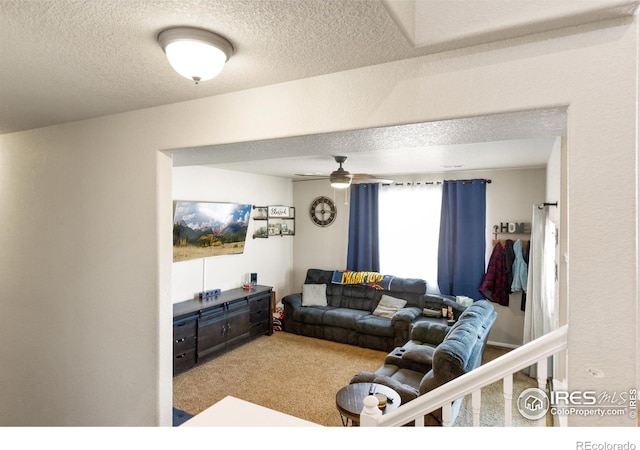 carpeted living area with a textured ceiling and a ceiling fan