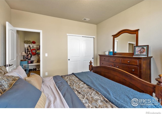 bedroom featuring a textured ceiling, visible vents, and a closet