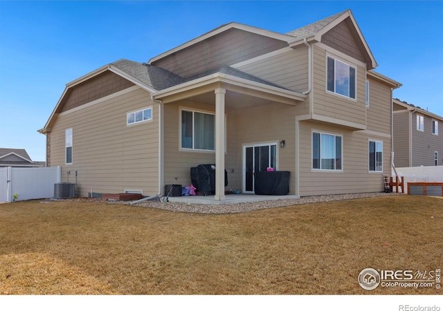 rear view of property featuring a patio area, fence, central AC unit, and a lawn