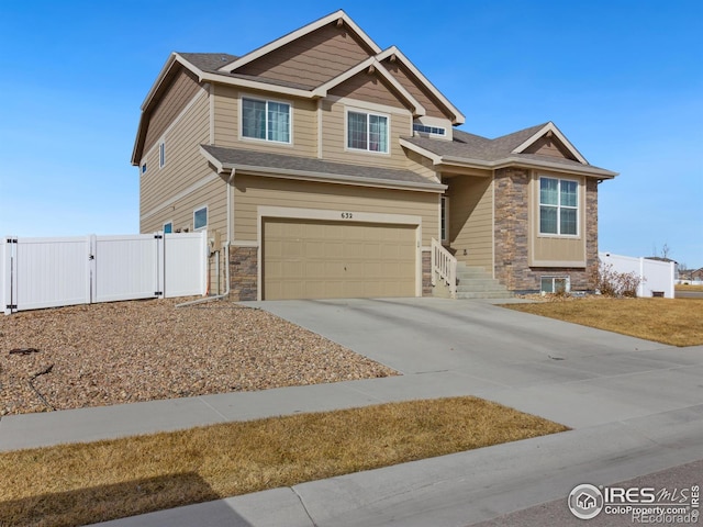 craftsman inspired home featuring a garage, fence, stone siding, driveway, and a gate