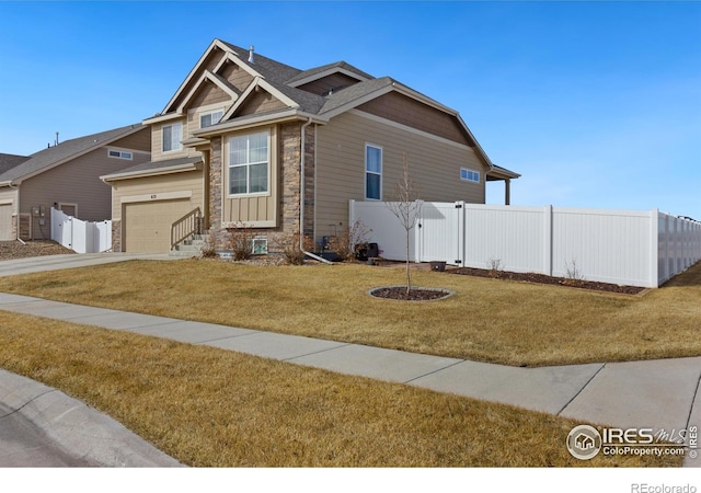 craftsman-style house with a garage, concrete driveway, fence, and a front lawn