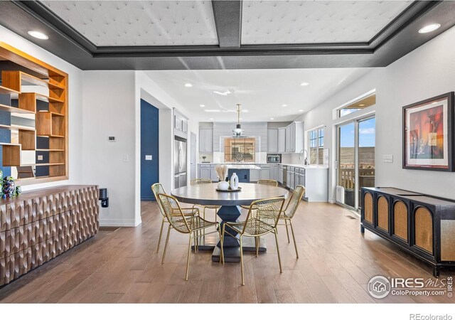 dining room featuring recessed lighting, baseboards, built in features, and wood finished floors