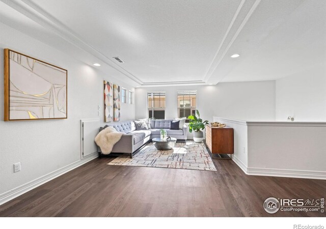 living room with visible vents, baseboards, and wood finished floors