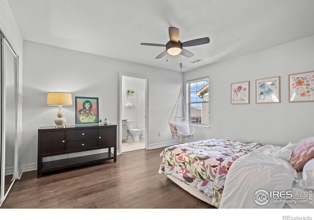 bedroom featuring visible vents, ensuite bathroom, wood finished floors, a closet, and baseboards