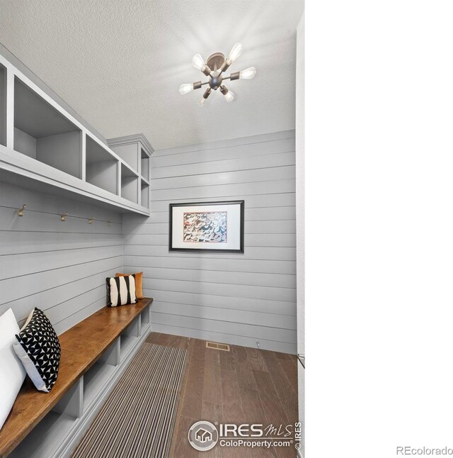 mudroom with dark wood finished floors and a textured ceiling