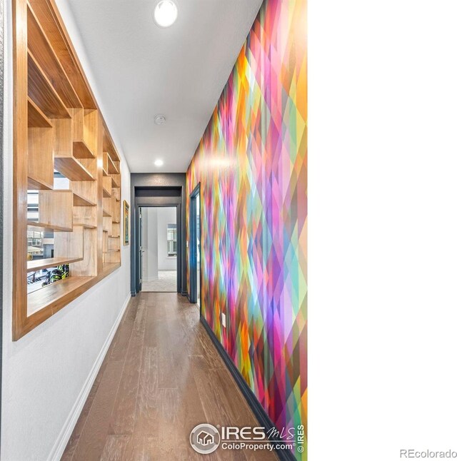 hall with baseboards and wood finished floors