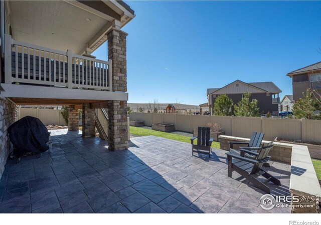 view of patio with grilling area, a fire pit, and a fenced backyard