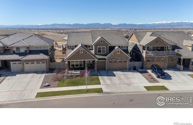 townhome / multi-family property featuring concrete driveway, a tiled roof, and a mountain view