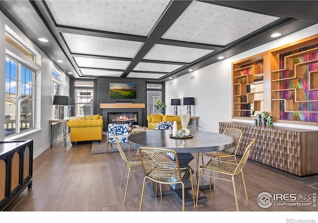 dining area with recessed lighting, coffered ceiling, a brick fireplace, and wood finished floors