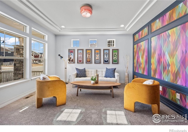 sitting room featuring a raised ceiling, carpet, visible vents, and baseboards