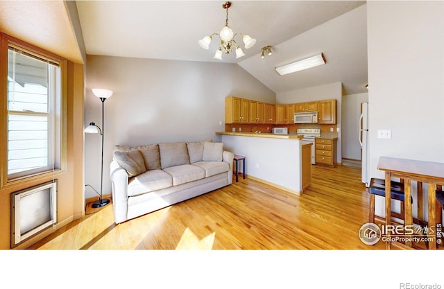 living room featuring light wood finished floors, baseboards, a chandelier, and vaulted ceiling