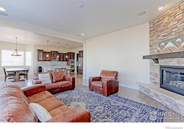 living room with a fireplace, baseboards, wood finished floors, and recessed lighting