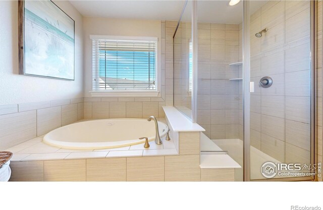 bathroom featuring a stall shower and a bath