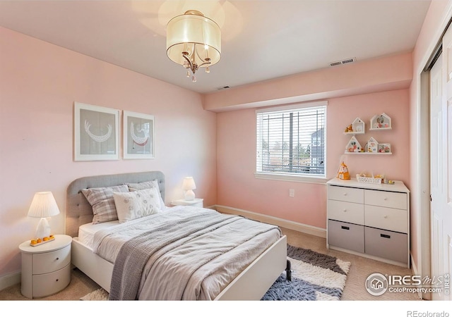 bedroom with baseboards, visible vents, a chandelier, and light colored carpet