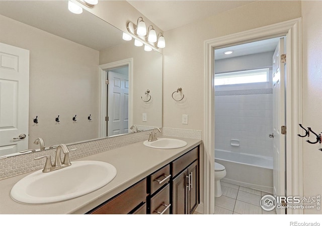 full bathroom featuring a sink, toilet, and double vanity