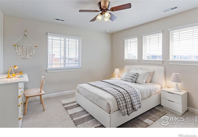 bedroom with light carpet, baseboards, visible vents, and a ceiling fan