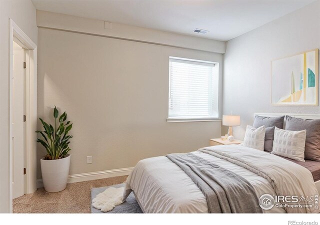 carpeted bedroom featuring visible vents and baseboards