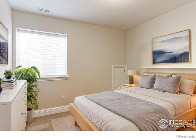 bedroom featuring baseboards, visible vents, and light colored carpet