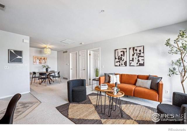 living area with carpet floors, baseboards, and visible vents