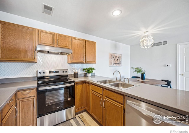 kitchen featuring under cabinet range hood, visible vents, stainless steel appliances, and a sink