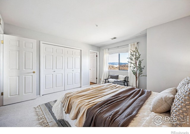 carpeted bedroom featuring a closet and visible vents