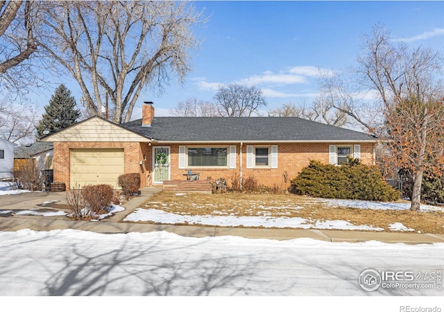 ranch-style home featuring an attached garage, driveway, a chimney, and brick siding