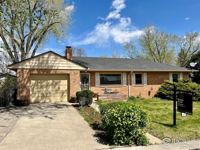 single story home featuring concrete driveway, a chimney, an attached garage, a front yard, and brick siding