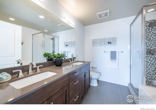 bathroom with a stall shower, visible vents, a sink, and double vanity