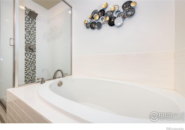 bathroom with a garden tub and a shower stall