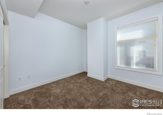 carpeted spare room with baseboards