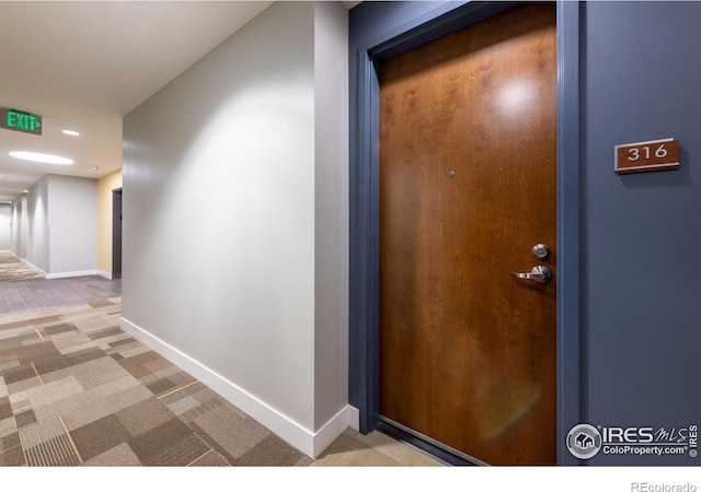 hallway featuring carpet floors and baseboards