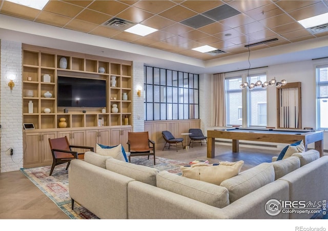 living room with brick wall, pool table, and visible vents