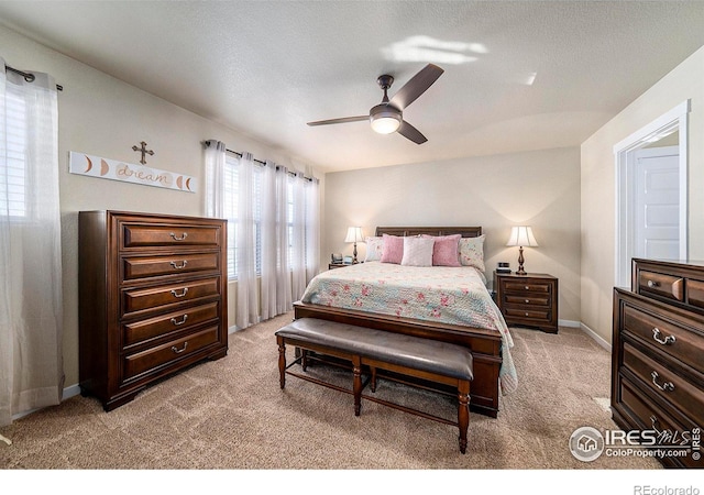 carpeted bedroom with ceiling fan, a textured ceiling, and baseboards