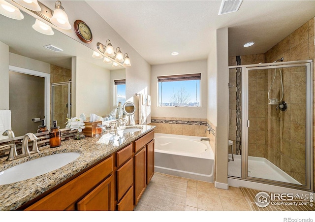 bathroom with tile patterned flooring, visible vents, a sink, and a shower stall