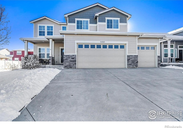 view of front of home featuring stone siding, concrete driveway, a porch, and a garage