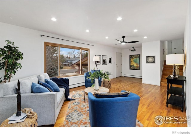 living area featuring stairs, recessed lighting, a baseboard radiator, and light wood-style floors