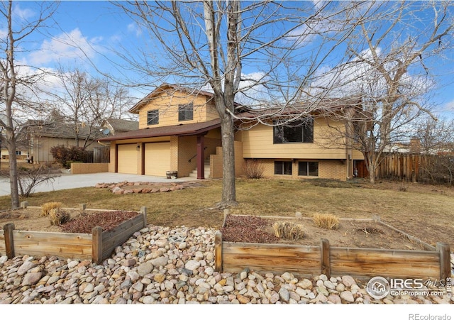 view of front facade featuring a front yard, fence, concrete driveway, and brick siding