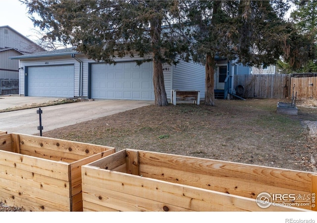 exterior space with a garage, driveway, and fence