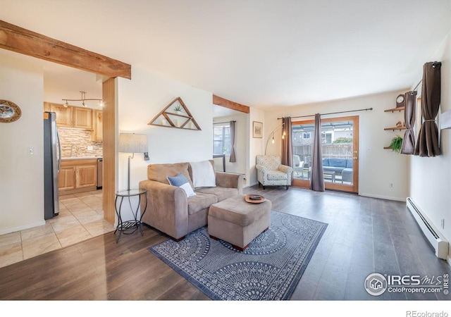 living area with light wood-type flooring, a baseboard radiator, and baseboards