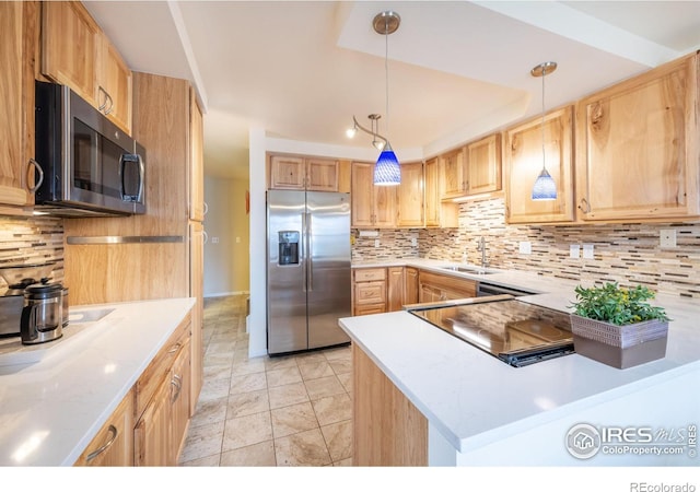 kitchen featuring light countertops, appliances with stainless steel finishes, a sink, and tasteful backsplash