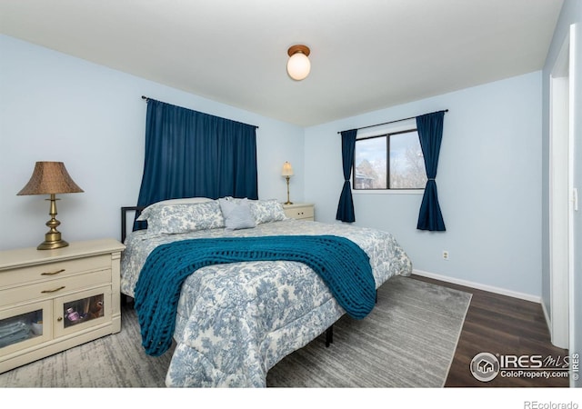 bedroom featuring baseboards and wood finished floors