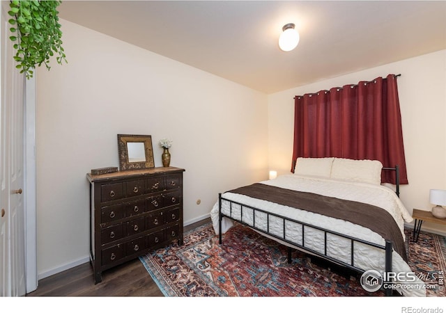 bedroom featuring dark wood finished floors and baseboards