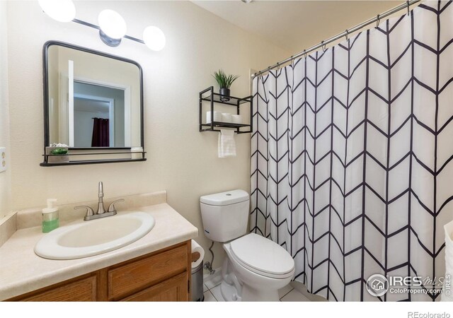 bathroom with curtained shower, vanity, and toilet