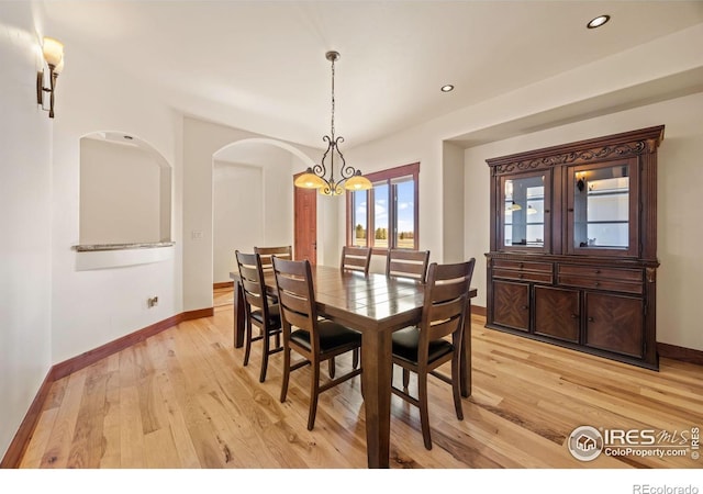 dining room featuring light wood-type flooring, a notable chandelier, baseboards, and recessed lighting