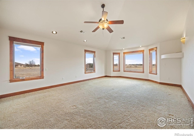 empty room featuring lofted ceiling, recessed lighting, visible vents, baseboards, and carpet