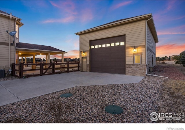 exterior space with an outbuilding, stone siding, and fence